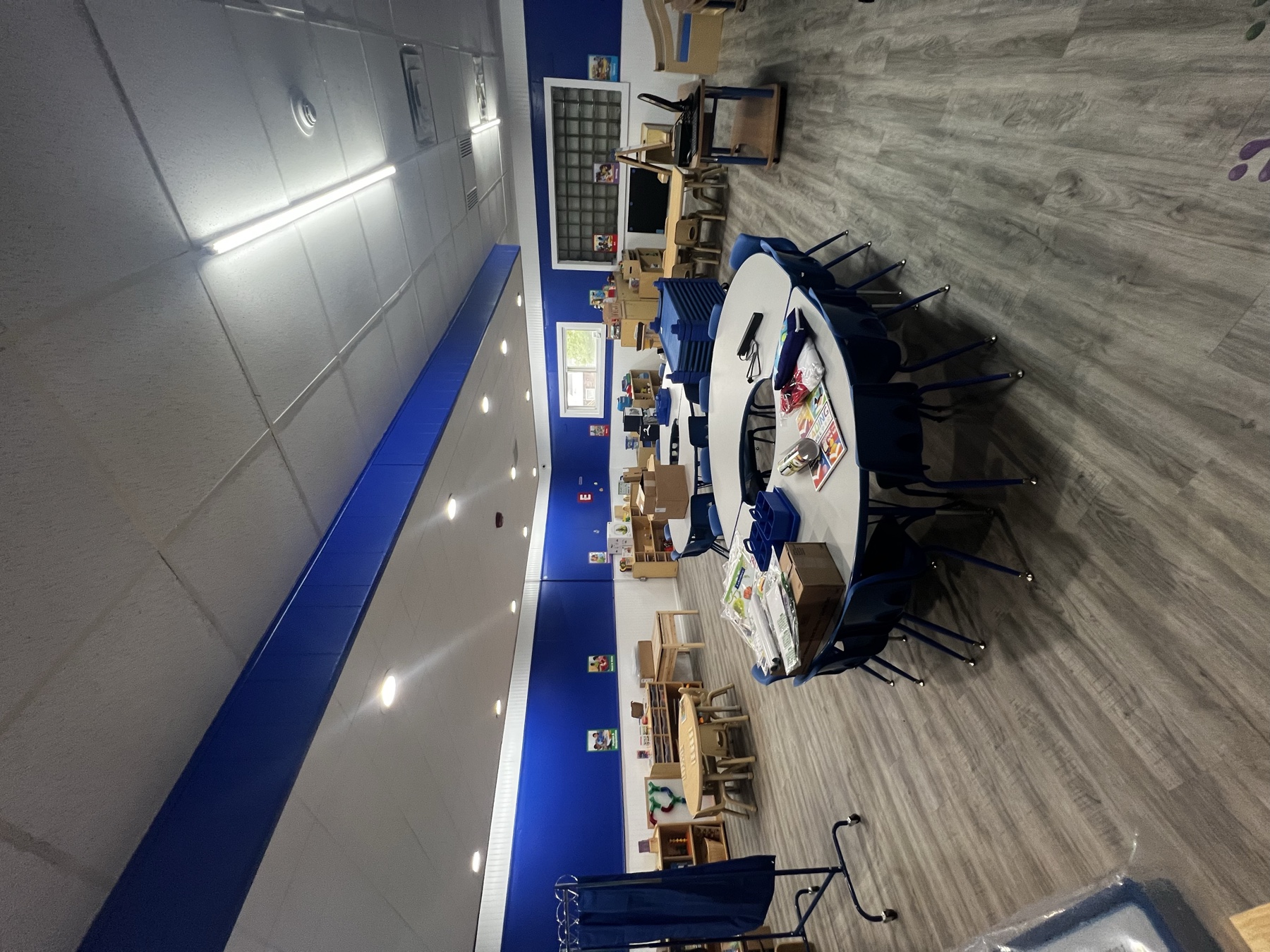Childcare classroom update with plank flooring, blue accent walls, and recessed lighting
