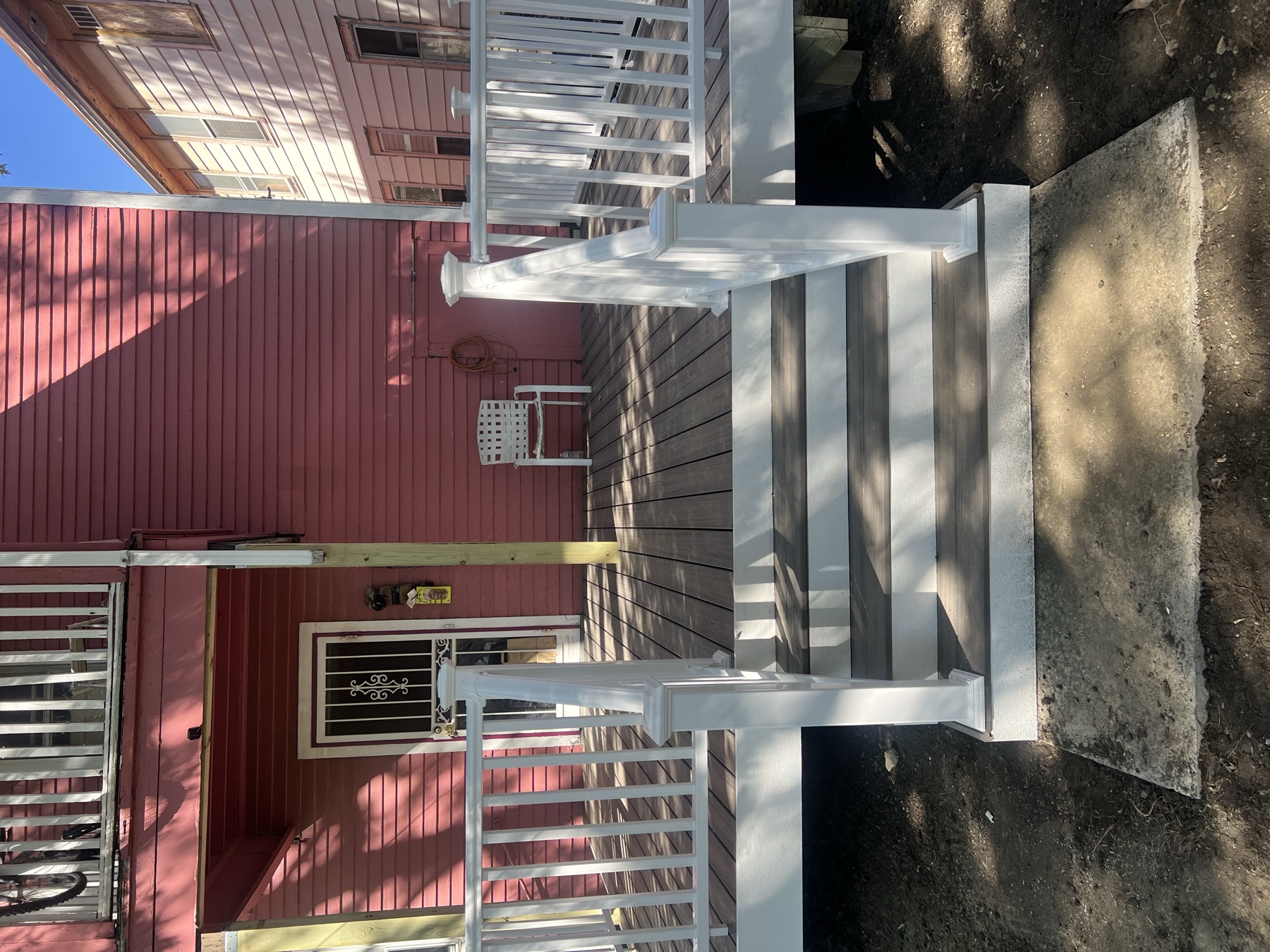 Composite front deck entry with white vinyl railing and stairs