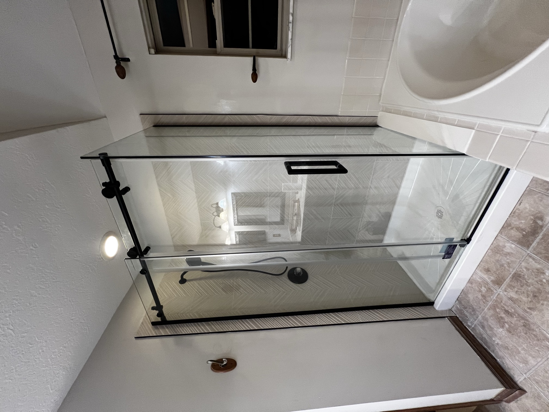 Bathroom shower with sliding glass door and black hardware